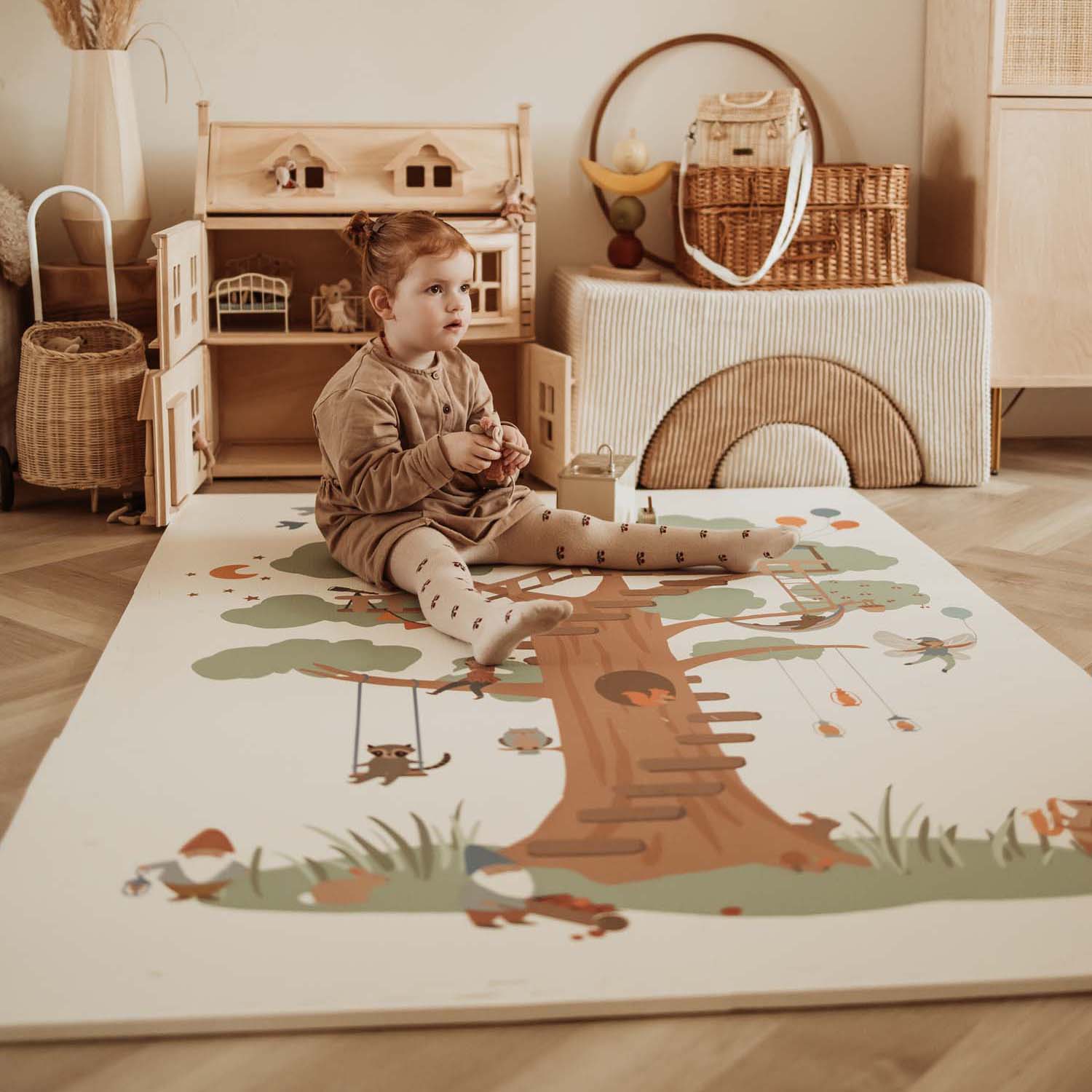 PlayandGo_EEVAA_treehouse_puzzlemat_child_is_sitting_on_the_mat_in_kidsroom_victorian_house_wooden_basket 2 in 1 Spielmatte EEVAA "Tree House" – Bild 1