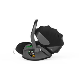 Side view of a gray infant car seat on its base with a black fabric canopy and raised carrying handle, featuring a subtle green accent on the base.