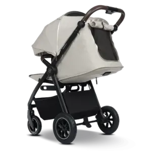 All-terrain baby stroller in beige bassinet with brown handle and black frame, large pneumatic wheels, and storage basket underneath.