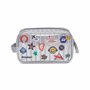 Silver zippered travel cosmetic bag covered with colorful stickers and patches on a striped background.