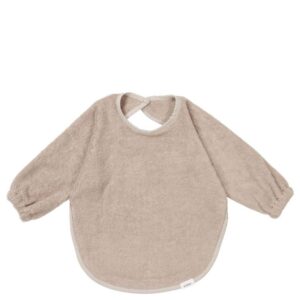 Soft beige baby bib with long sleeves, designed to catch spills during feeding or teething.