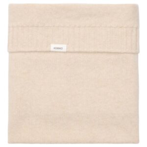 Beige folded knit blanket with a small white label on the edge