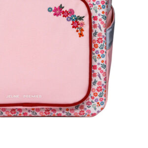 Pink backpack with floral border and small embroidered flower cluster on top left, brand 'JEUNE PREMIER' visible at bottom left of panel