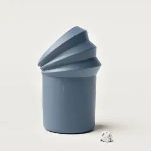 Blue cylindrical container with a stacked spiral top on a pale background; a crumpled paper ball sits nearby.