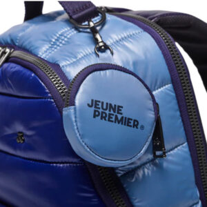 Blue padded backpack with purple zippers and a round Jeune Premier logo tag on the front pocket.
