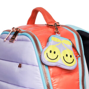 Colorful kids' backpack with orange and lavender panels, turquoise zippers, and a yellow smiley-lemon tag hanging from the zipper pull.