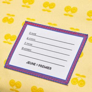 White form card with lines for Name, School, Phone and Address, bordered in blue and red, on a yellow cherry-patterned background.