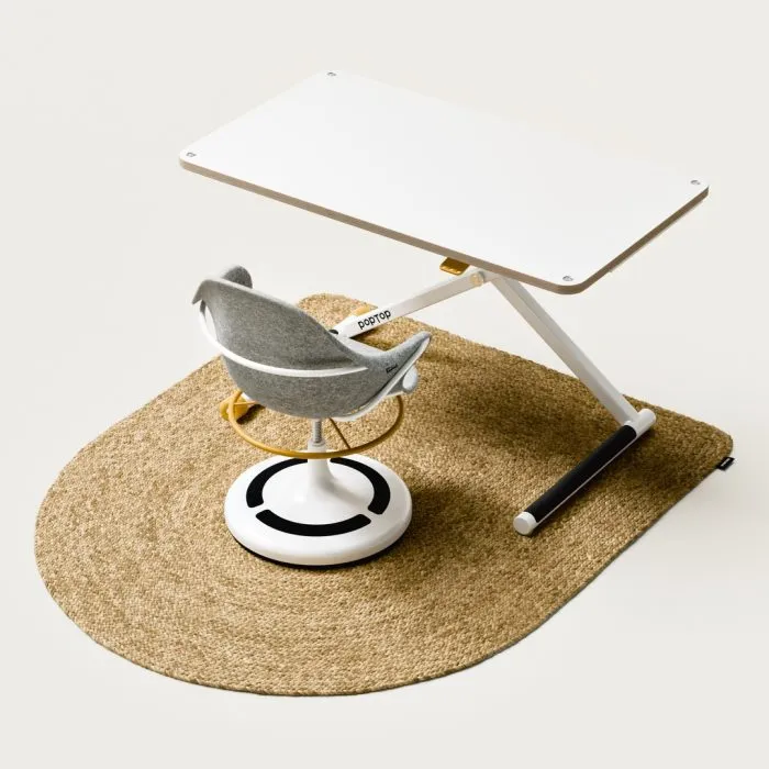 teppich1 White adjustable desk with a small grey swivel chair, placed on a round beige rug.